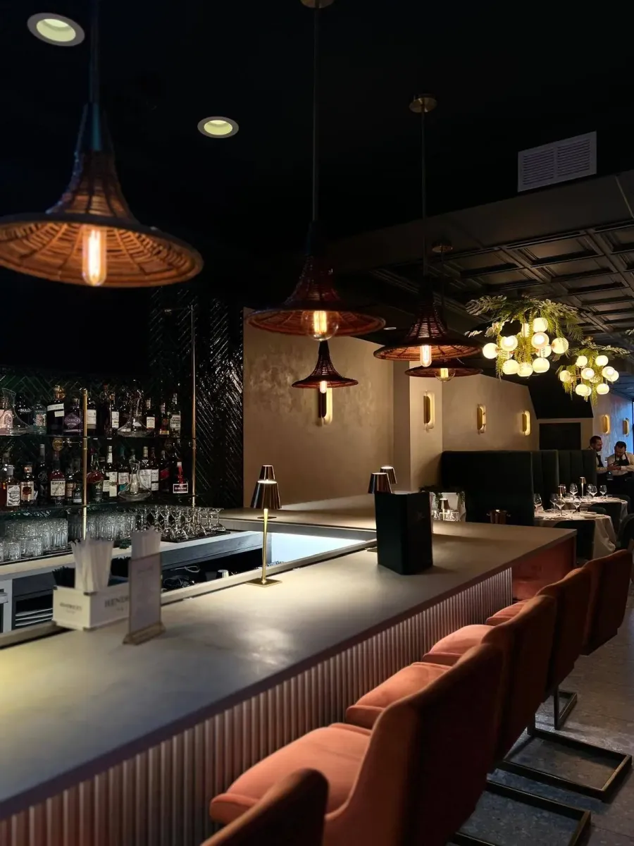 The long bar at Casa Stellina under copper pendant lights