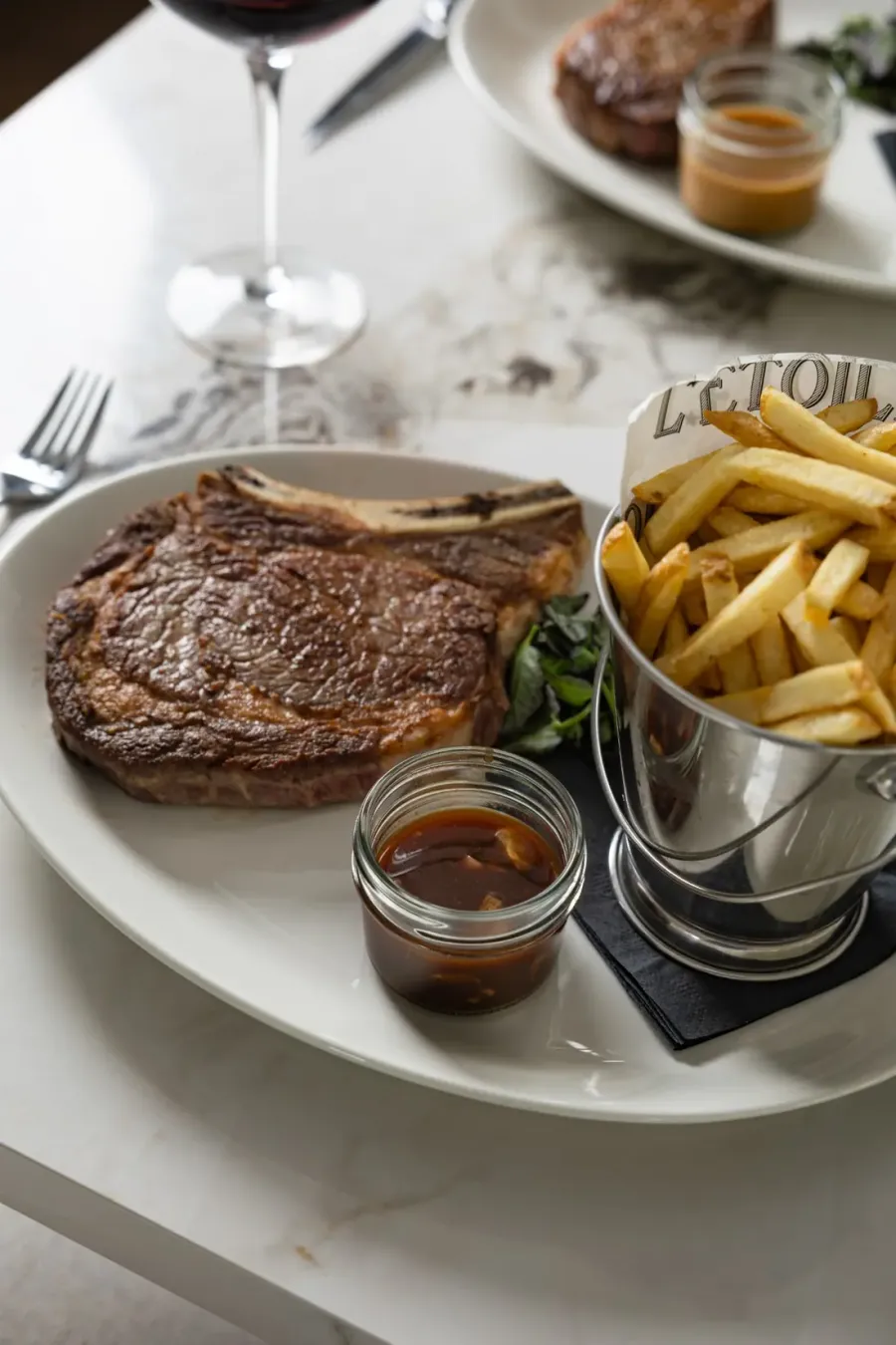 Steak frites with sauce and a copper cup of fries
